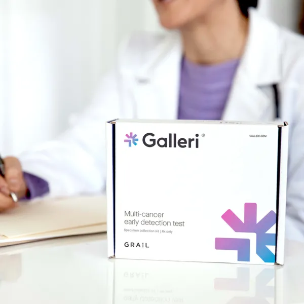 close up image of the Galleri test box with a female physician out of focus in the background